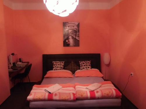 a bedroom with a bed with orange walls at Penzion Netolice in Netolice