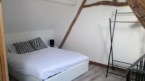 a small bedroom with a white bed and a ladder at La Petite Maison in Condat-sur-Vézère