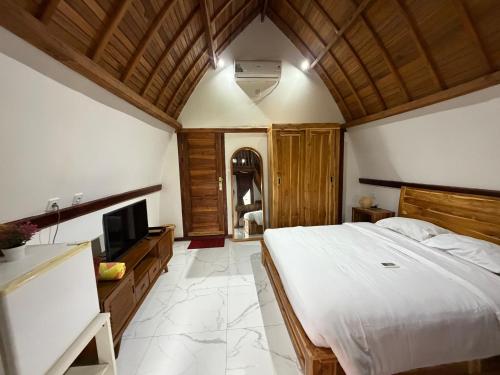 a bedroom with a large bed and a television at Villa Aiden Bungalow 3 near luwatu in Ungasan