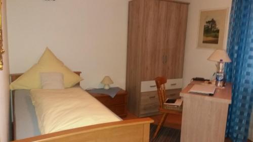 a small bedroom with a bed and a desk and a desk at Landhaus Irma in Bad Füssing
