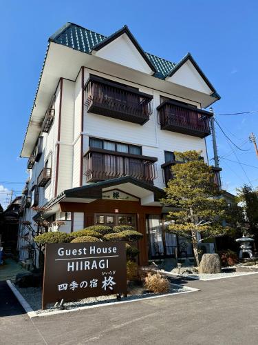 a guest house himachi with a sign in front of it at Guest House HIIRAGI in Yamanakako