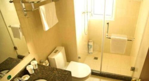 ein Badezimmer mit Toilette und Glasdusche in der Unterkunft GreenTree Inn Jiangsu Huaian Bus Terminal North Station Huaihai North Road Business Hotel in Huai'an