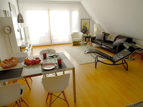 una sala de estar con una mesa y un sofá en Seeperle 2, en Meersburg