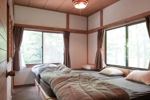 deux lits dans une chambre avec deux fenêtres dans l'établissement Sunland S152 - Vacation STAY 54960v, à Mihara