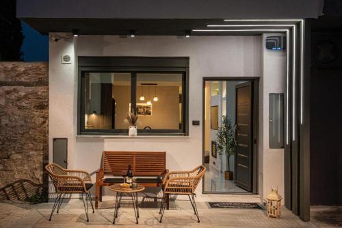 a patio with a table and chairs and a building at Savvy Apartments in Áyioi Dhéka