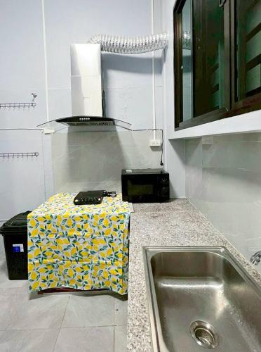 a kitchen with a sink and a box on the counter at Bird Hostel Chiangrai in Chiang Rai