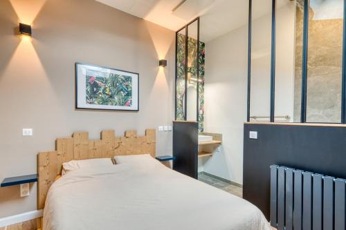 ein Schlafzimmer mit einem großen Bett und zwei Fenstern in der Unterkunft La Petite Maison Centrale - T4 - Centre Montluel in Montluel