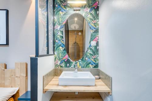 ein Badezimmer mit Waschbecken und Spiegel in der Unterkunft La Petite Maison Centrale - T4 - Centre Montluel in Montluel