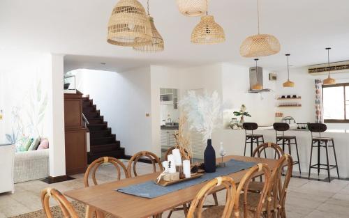 une cuisine et une salle à manger avec une table et des chaises en bois dans l'établissement Rayong Beach House, à Ban Bang Nok