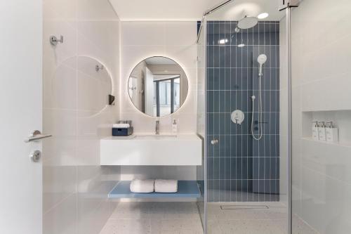 Xóm TramAmigo Sol Phan Thiet的浴室里有淋浴、洗手池和镜子。