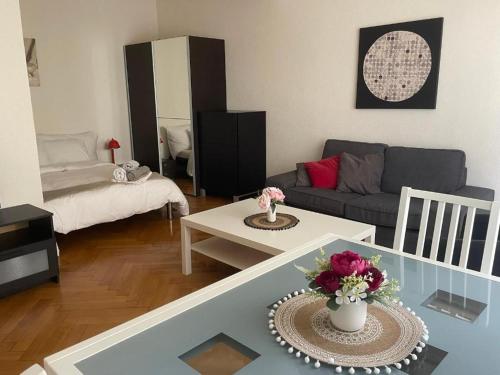 Una sala de estar con un sofá y una mesa con flores. en Appartement calme à Lausanne, en Lausana