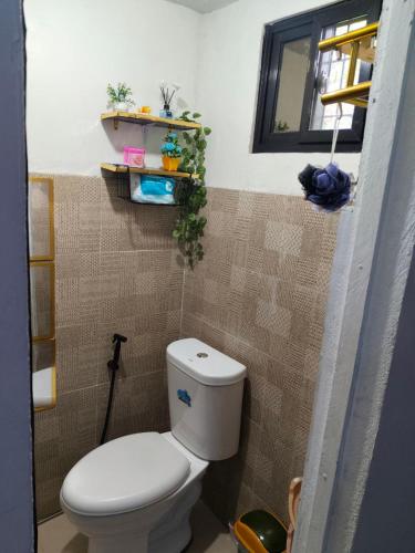 un piccolo bagno con servizi igienici e finestra di Ciel's Haven Free Breakfast a Binangonan