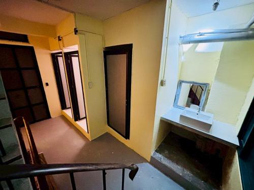 a bathroom with a sink and a mirror on the wall at Sukhum Charoen Krung Tak-Sin bridge guest house in Bangkok