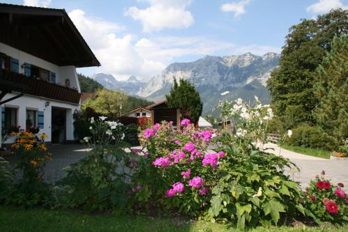 a garden with flowers in front of a house at Haus Angerbichl in Ramsau