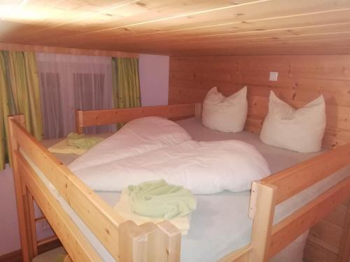 a bedroom with two beds in a wooden cabin at Dreimäderlhaus in Aussersiggam