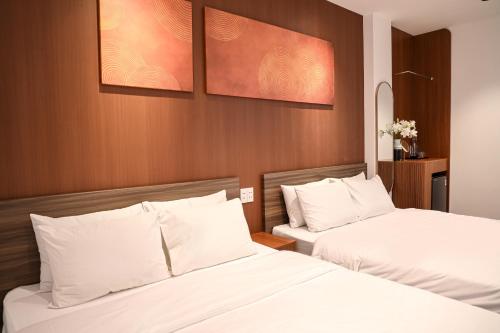 duas camas em um quarto de hotel com lençóis brancos em Chingu Boutique 2 em Vung Tau