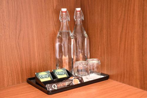 duas garrafas de refrigerante e copos em uma bandeja sobre uma mesa em Chingu Boutique 2 em Vung Tau