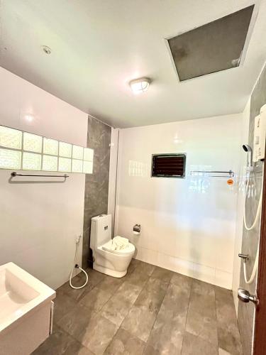 a bathroom with a toilet and a sink at The Chevalley Beach Resort in Ban Ma Ngang