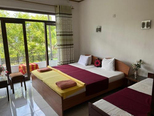 une chambre avec deux lits et une fenêtre dans l'établissement Kandy IVY Banks Holiday Resort, à Kandy