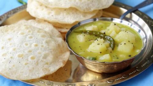 um prato com uma tigela de molho e um pouco de pão em Coral Beach Resort Mandarmoni em Mandarmoni