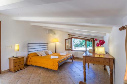 ein Schlafzimmer mit einem Bett, einem Tisch und einem Schreibtisch in der Unterkunft Can Xilla by Sealand Villas in Alcanada