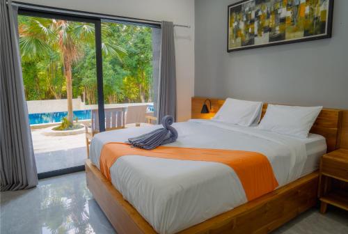 ein Schlafzimmer mit einem Bett und einem großen Fenster in der Unterkunft Vasachio Guest House in Uluwatu