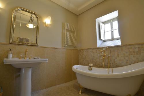 um banheiro com banheira, pia e espelho em Palais Bayram em Tunes