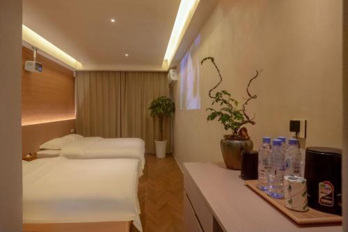 una camera d'albergo con due letti e bottiglie d'acqua di Tangyin Courtyard Hotel a Xi'an