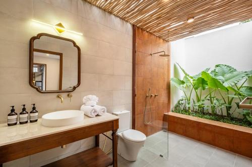 un baño con lavabo y espejo en Villa Mewangi by SooBali Private Pool in Sanur, en Sanur