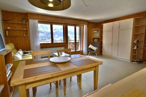 a living room with a wooden table and chairs at Studio Le Cocon in Champéry