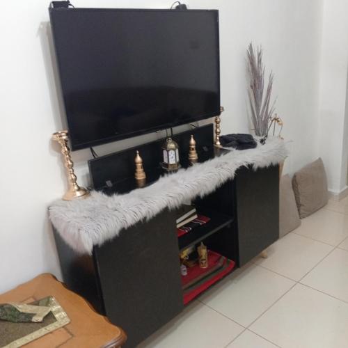ein schwarzes Entertainment-Center mit einem Flachbild-TV in der Unterkunft شقة مفروشة عائلية in Amman