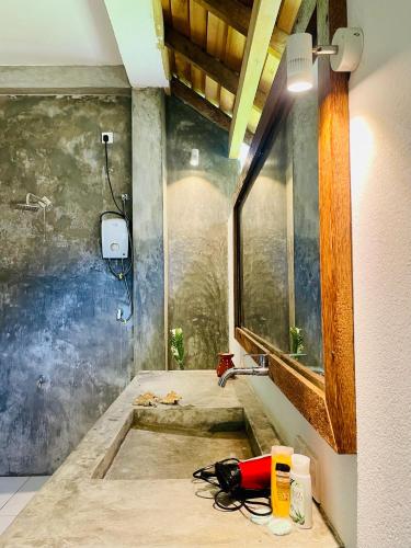 a bathroom with a shower with a sink in it at Baker's cottage in Kosgoda