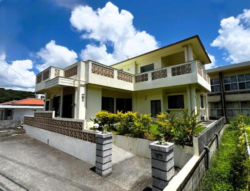 a house with a balcony on the side of it at やんばる別荘三原でーじまぎー -Yanbaru stay MIHARA VILLA GRANDE- in Nago
