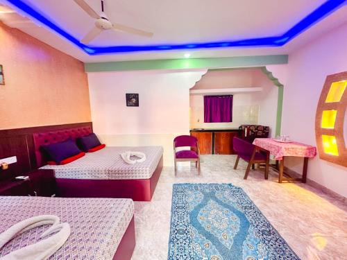 una habitación con dos camas y una mesa y sillas en R mansion, en Calangute