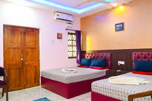 una habitación con dos camas y una ventana en R mansion, en Calangute