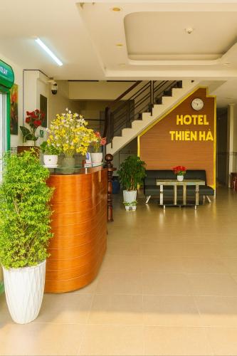 eine Lobby mit einem Hotel-Thenha-Schild und Topfpflanzen in der Unterkunft Thiên Hà Hotel in Ho-Chi-Minh-Stadt