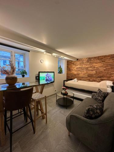 ein Wohnzimmer mit einem Sofa, einem Tisch und einem TV in der Unterkunft A Place To Stay Stavanger, apartment 1 in Stavanger