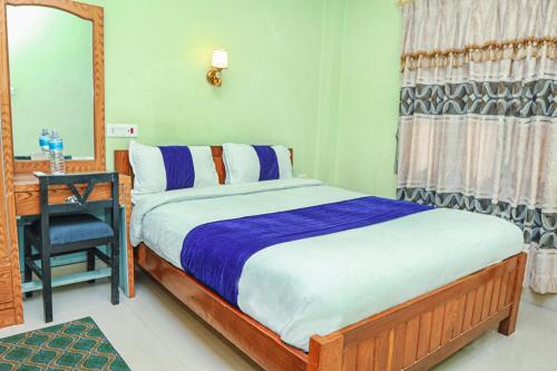 Un dormitorio con una cama, un escritorio y un espejo. en Gairibari Resort, en Jhawāni