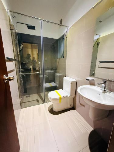 a bathroom with a shower and a toilet and a sink at The Golfside Luxe in Gonapola