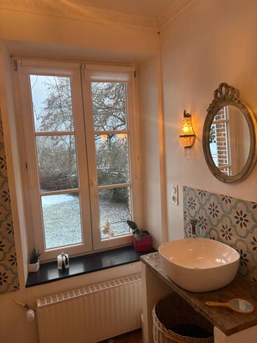 a bathroom with a sink and two windows at Halte dans le Perche 