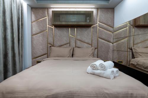 ein Schlafzimmer mit einem Bett und zwei gewalzten Handtüchern in der Unterkunft VNS LUXURY STAY apartment in Târgovişte