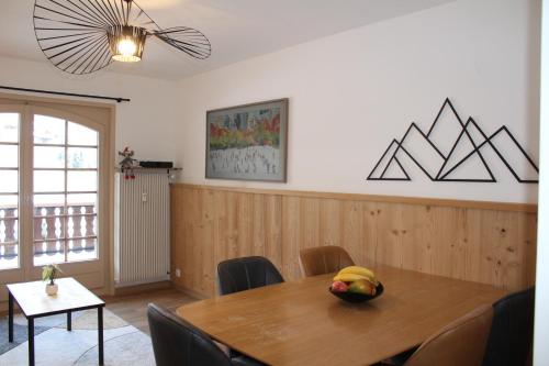 a dining room with a wooden table and chairs at Centre, Pistes à pied, Vue magnifique, Calme, Tout renové, Grande terrasse in Les Gets