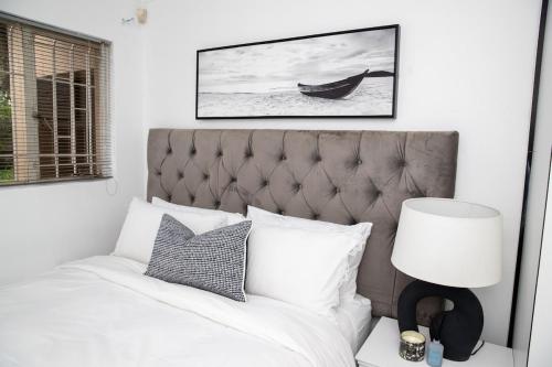 a bedroom with a bed and a picture of a boat at Serenity on Geelhaak in Kempton Park