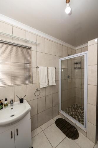 a bathroom with a shower and a sink and a shower at Serenity on Geelhaak in Kempton Park