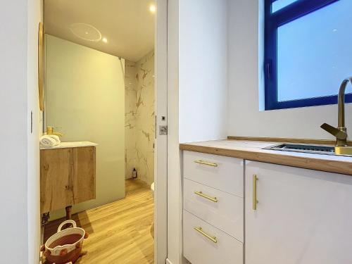 a kitchen with white cabinets and a sink and a window at Avo Maria 2 House by AH in Senhora do Rosário