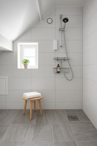 a white bathroom with a stool and a shower at A Place To Stay Stavanger, apt 3 in Stavanger