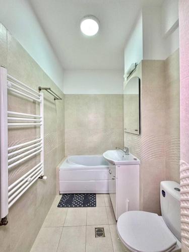 a bathroom with a tub and a toilet and a sink at IN APART HOTEL in Bucharest