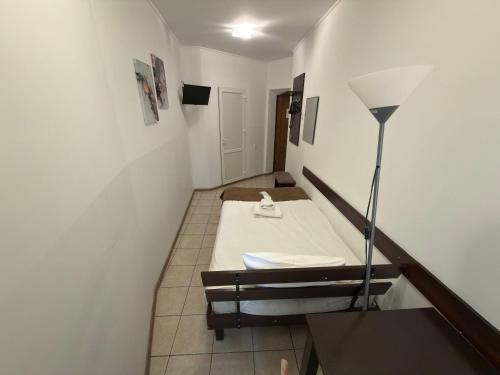 a small room with a bed and a lamp at Готель Цісар in Lviv