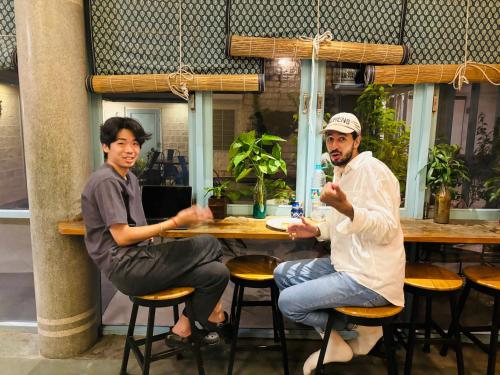 two men sitting at a table in a restaurant at Jaipur Jantar Hostel in Jaipur