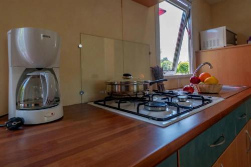 a kitchen counter with a coffee maker and a stove at ZEcamping 4 étoiles familial - parc aqua et soirées animées in Murol